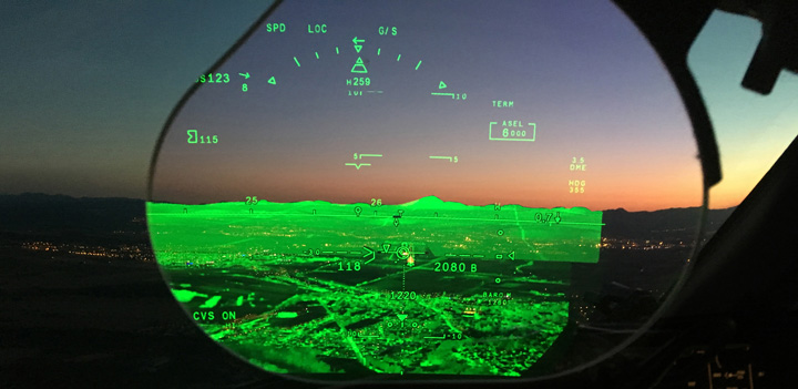 View from the cockpit of a Falcon luxury business jet as it flies toward the setting sun. The Falcon Eye combined vision system displays terrain details the naked eye cannot see.