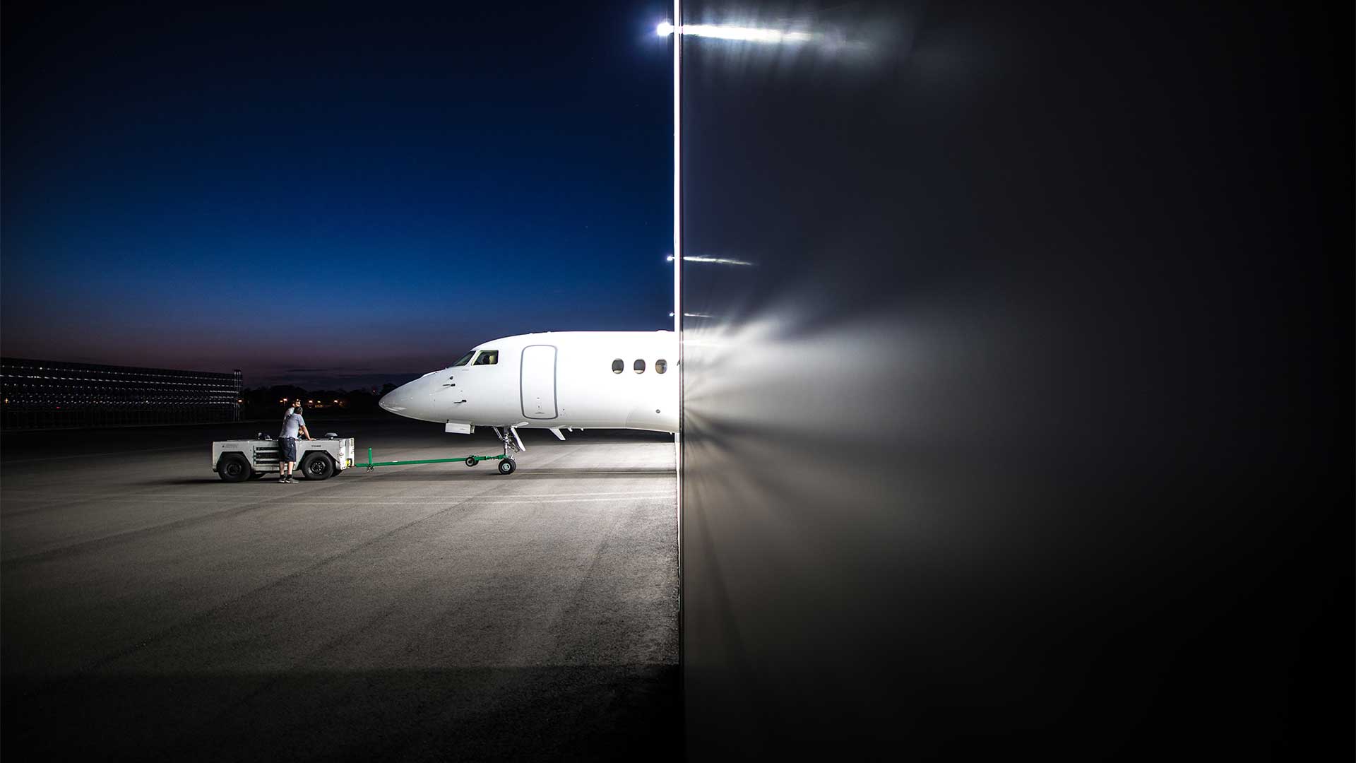 Image of a Falcon 8X emerging from the hangar in LIttle Rock, Arkansas at night.